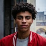 Portrait of a young man in a red jacket of barber shop